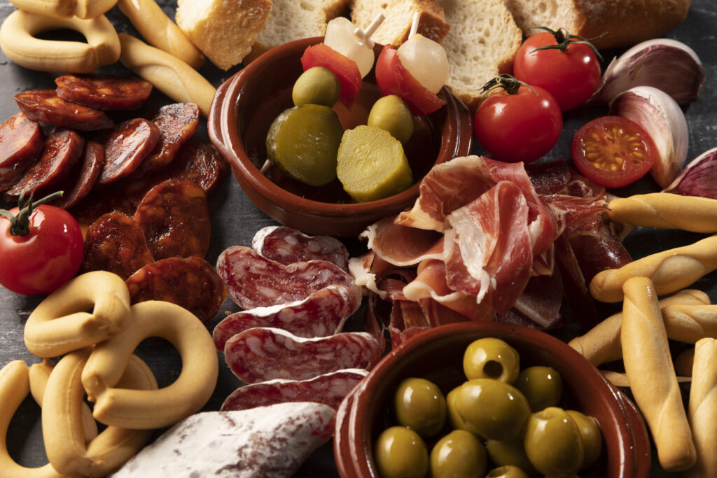 Ein Tisch voll mit Serrano Schinken, Chouriço und ander Iberischen Delikatesse